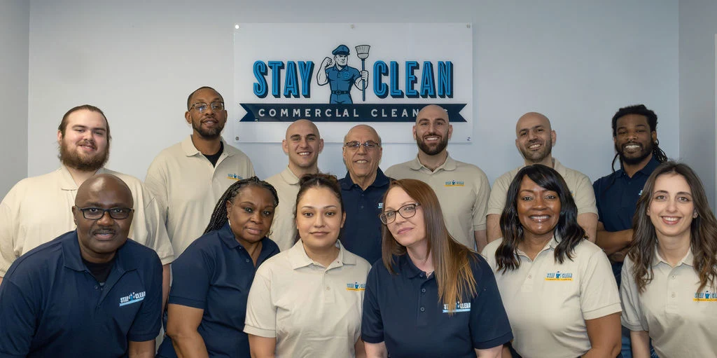 The full Stay Clean Solutions team in front of the company sign
